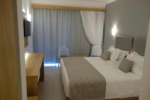 a hotel room with a bed and a television at Rhodos Horizon City-Adults Only in Rhodes Town