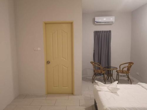 a room with two beds and a yellow door at Luna Guesthouse 露娜旅馆 in Semporna
