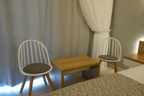 a bedroom with two chairs and a table and a bed at Rhodos Horizon City-Adults Only in Rhodes Town
