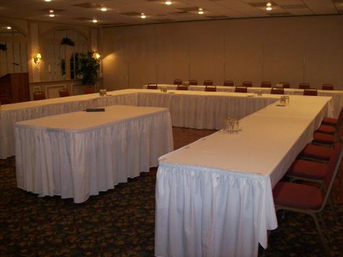 a row of tables with white linens in a room at 1863 Inn of Gettysburg in Gettysburg