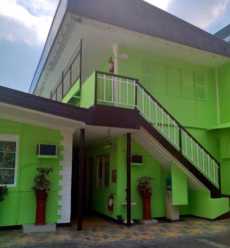 a green building with a staircase on the side of it at AMBIANZA APARTELLE in Manila