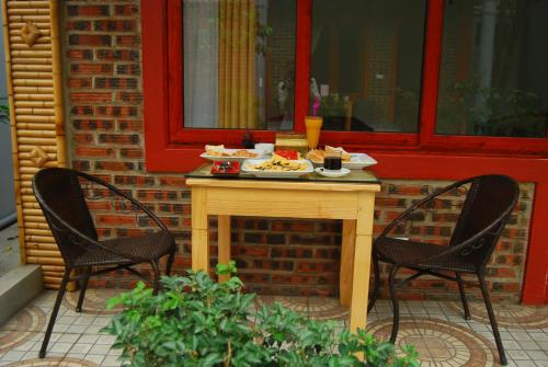 a table with a plate of food and two chairs at Tam Coc Tropical Garden in Ninh Binh