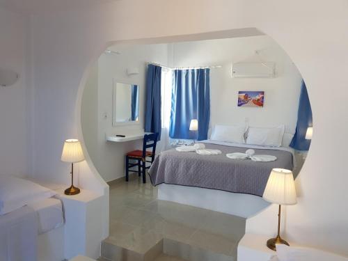 a bedroom with a bed and two lamps in it at Caldera View Resort - Adults Only in Akrotiri