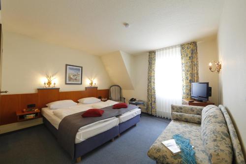 コッヘムにあるHotel Karl Nossのベッドとソファのあるホテルの部屋