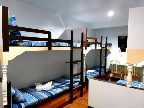 a room with three bunk beds in a hostel at AMBIANZA APARTELLE in Manila