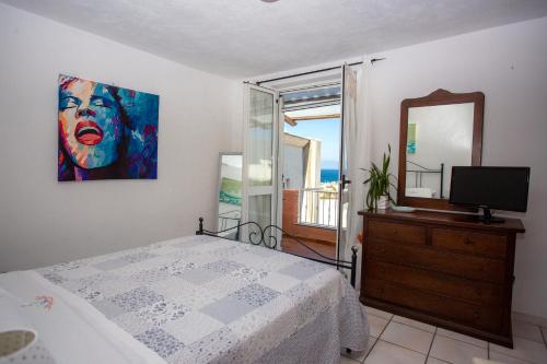um quarto com uma cama, um espelho e uma televisão em Casa sul lungomare di Forio d'Ischia - "Serpico sea & more" em Ischia