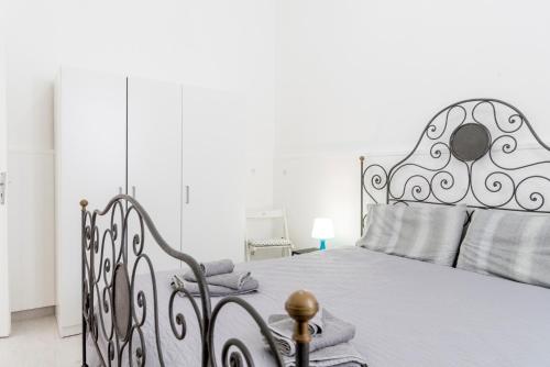 una camera bianca con letto con struttura metallica di Casa Trinacria a Marina di Ragusa