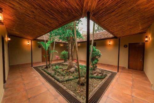 an indoor garden in the middle of a room with trees at Green Mansions Jungle Resort in Sauraha
