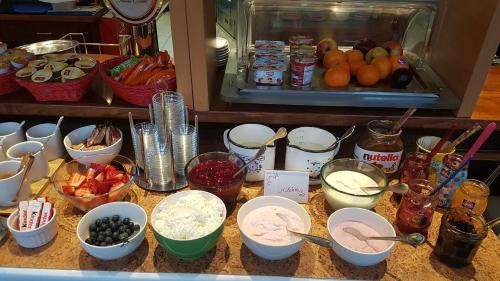 a counter topped with bowls of food and other ingredients at Schillers Hotel & Café - GARNI - in Lüdenscheid