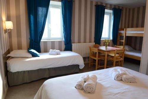 une chambre d'hôtel avec deux lits et une table dans l'établissement Le Chateau de Chantereine, à Criel-sur-Mer