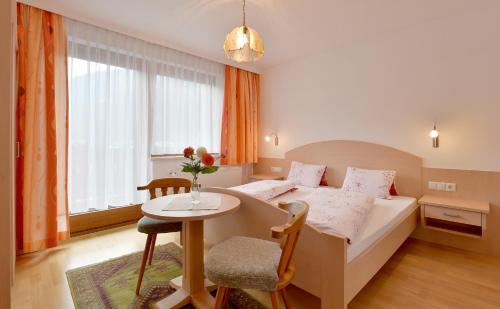 a hotel room with a bed and a table at Haus Dejakom Mayrhofen in Mayrhofen