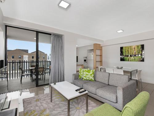 a living room filled with furniture and a large window at Atrio Apartments in Brisbane