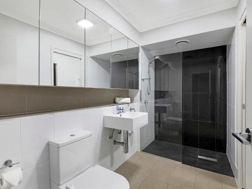 a bathroom with a toilet and a sink and a shower at Atrio Apartments in Brisbane
