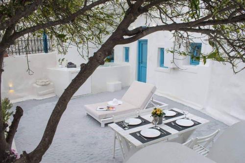 a patio with a table and chairs and a tree at Stoa Cave Villas in Mesaria