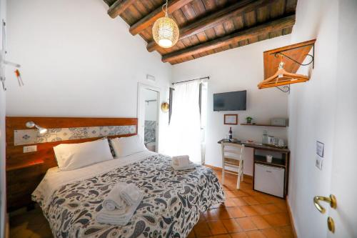 a bedroom with a bed and a desk and a window at Agrodolce B&B in Cefalù