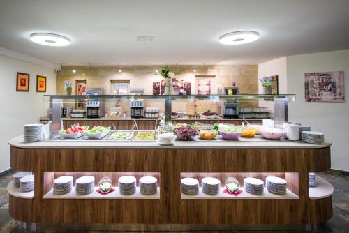 a buffet line with plates and bowls of food at BSA Gradina Hotel & Aquapark - All Inclusive in Golden Sands