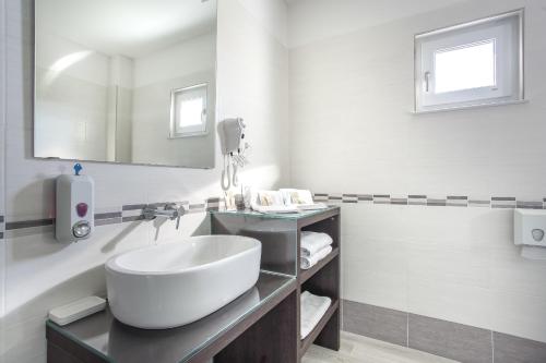 a white bathroom with a sink and a mirror at Country House Campofiore in Pontelongo