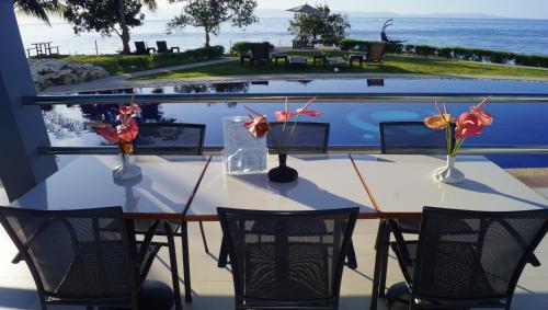 uma mesa com cadeiras e flores em cima de uma piscina em Panglao Sea Resort - Tangnan em Panglao City