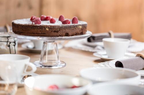 a chocolate cake with raspberries on a table at Chalet Hafling Zoila in Avelengo