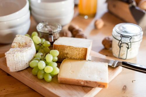 a cutting board with cheese and grapes and a knife at Chalet Hafling Zoila in Avelengo