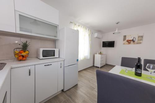 Una cocina con un refrigerador blanco y un microondas. en Apartman Ankica, en Kaštela