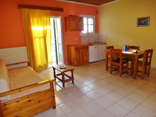 a living room with a table and a kitchen at Lefkothea Apartments in Lefkada