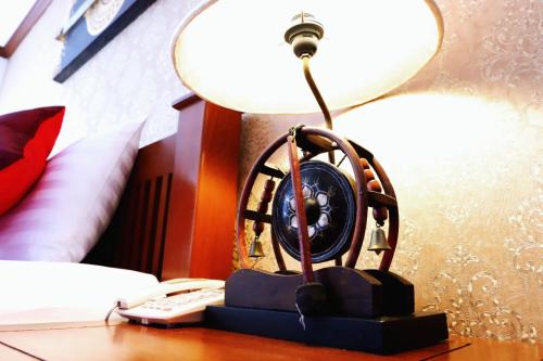 a clock sitting on a desk next to a lamp at Aiyaree Place Hotel SHA PLUS in Jomtien Beach