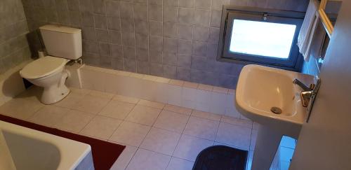 een badkamer met een toilet, een wastafel en een raam bij Longo Mai in Le Sambuc