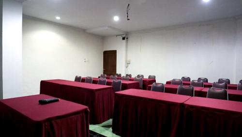 a conference room with red tables and chairs in it at Diana Hotel Jogja in Yogyakarta