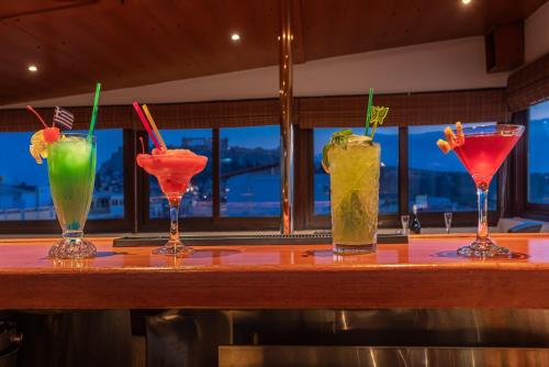 a group of four cocktails sitting on a bar at Attalos Hotel in Athens