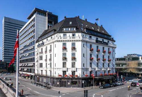 um edifício branco com um telhado preto numa rua da cidade em ProfilHotels Copenhagen Plaza em Copenhague