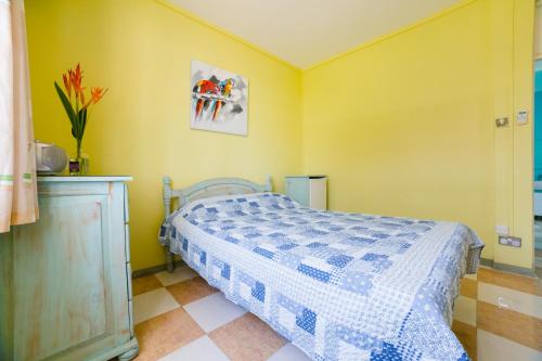 a bedroom with a bed with a blue and white quilt at Villa Bella Charming Beachfront Guesthouse in Blue Bay
