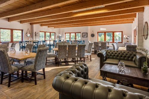 a dining room with leather chairs and tables and tablesktop at Roydon Marina Village Lodges in Roydon