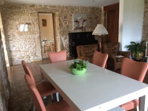 una sala da pranzo con tavolo bianco e sedie rosa di Casa da Trapa a Oliveira de Azeméis