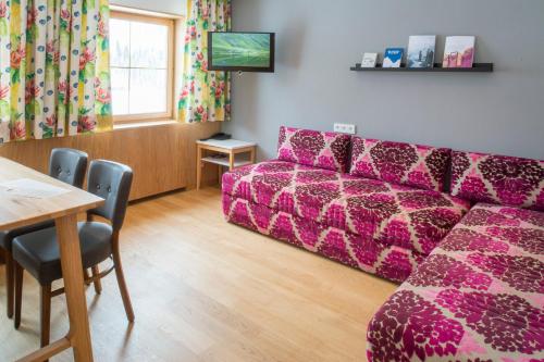 a living room with a couch and a table at Hotel Stäfeli in Lech am Arlberg