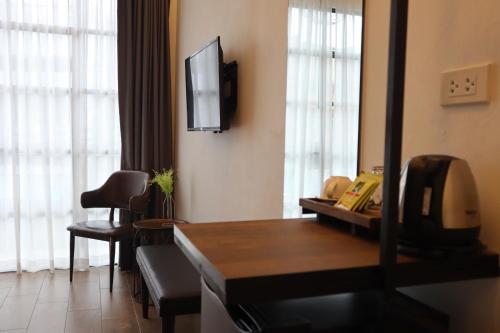 a living room with a television and a room with a couch at Goodnight Poshtel + Free Netflix in Hat Yai