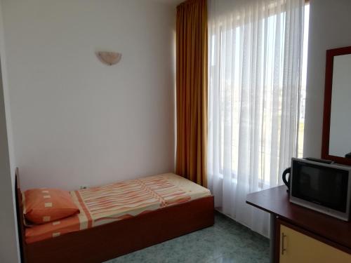 a small bedroom with a bed and a window at Svetlana Hotel in Byala