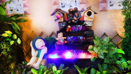 a water fountain with two dolls standing in front of a house at Aiyaree Place Hotel SHA PLUS in Jomtien Beach