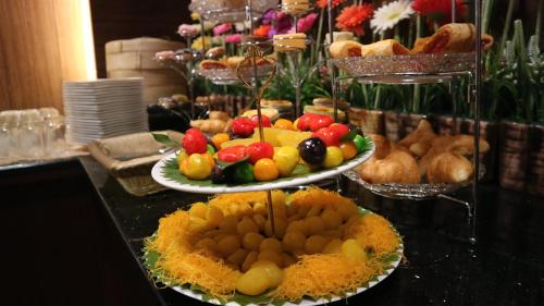 a buffet with two plates of fruit on a table at Aiyaree Place Hotel SHA PLUS in Jomtien Beach