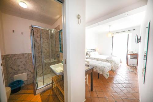 łazienka z 2 łóżkami, prysznicem i umywalką w obiekcie Agrodolce B&B w Cefalù