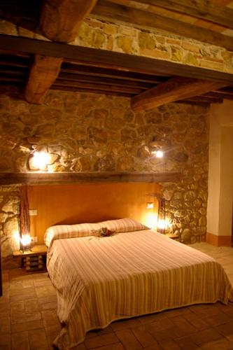 a bedroom with a large bed in a stone wall at B&B Casale di Poggioferro in Scansano