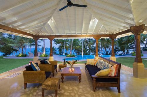 a pavilion with couches and chairs and a table at Villa Abiman in Dickwella