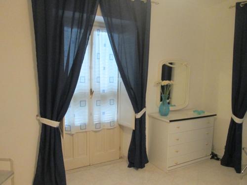 a window with black curtains and a dresser and a mirror at Casa Margherita in Minori