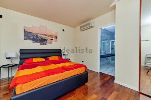 a bedroom with a bed with orange and yellow sheets at Villa Anna in Brenzone sul Garda