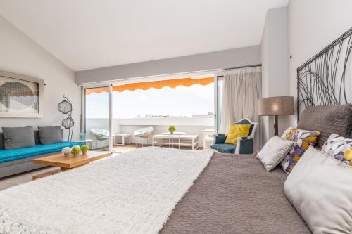 a bedroom with a large bed and a living room at Cabanas Green Apartment Ria Formosa in Cabanas de Tavira