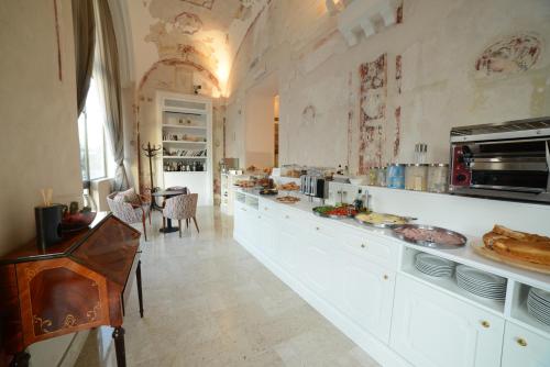 a large kitchen with white cabinets and a table at Hotel Vittoria in Pompei