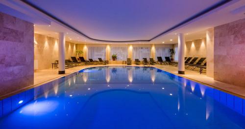 a large swimming pool in a hotel lobby at Hotel Fameli in Valdaora