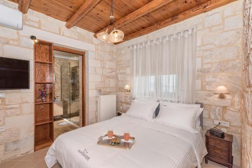 Un dormitorio con una cama grande en una pared de piedra. en Villa Freedom, en Kókkinon Khoríon