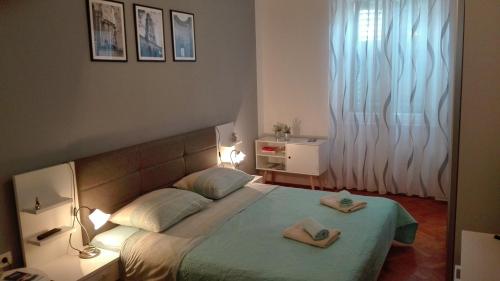 a bedroom with a bed with two towels on it at Rooms Šećer in Split