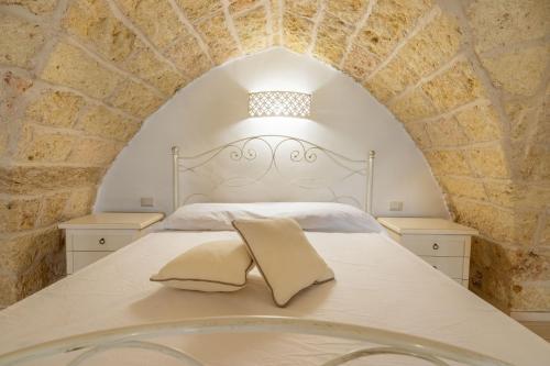 un letto bianco con due cuscini sopra di Conte Luxury Apartment by Salento Affitti a Racale